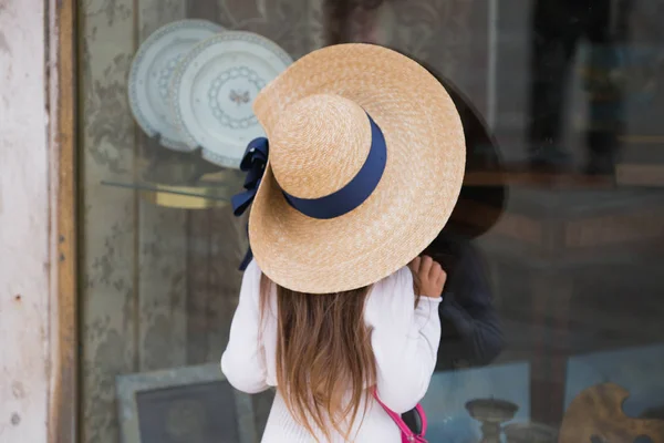 Маленькая девочка смотрит на витрину магазина — стоковое фото