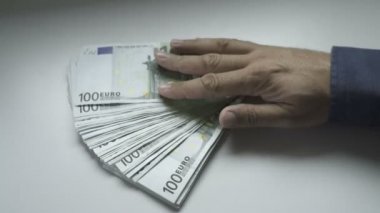 Businessmans el yüz Euro faturaları bir masada sayma
