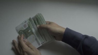 Businessmans el yüz Euro faturaları bir masada sayma