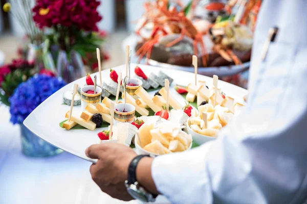 Garçom serve pratos de frutos do mar frescos — Fotografia de Stock