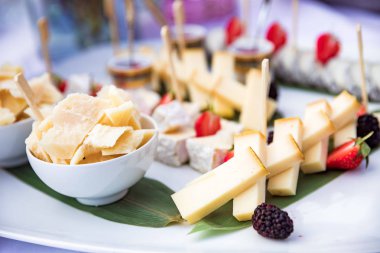 Plaka üzerinde armut ve çilek yalanla peynir