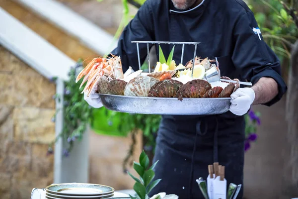 Waiter serves fresh seafood platter — Stock Photo, Image