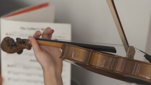 Ребенок играет на скрипке с нотами — стоковое видео