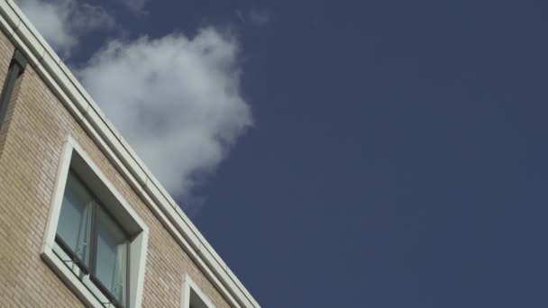 Plane flies far away in sky above house — Stock Video