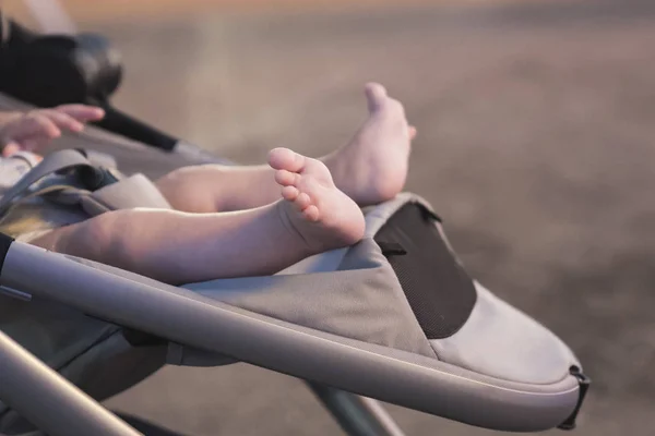 Newborn baby barefoot sleeping in stroller outdoors — Stock Photo, Image