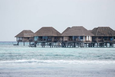 Bungalows at the beach in Maldives clipart