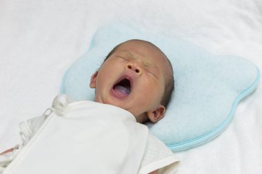Asya şirin yeni doğan bebek beyaz havlu üzerinde uyku.