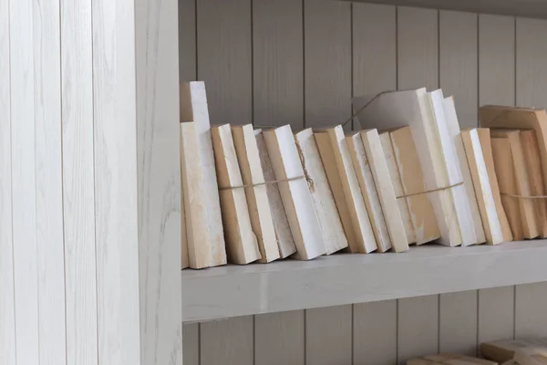 Bookshelf is white book with wooden white shelf background.