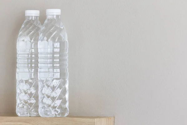 Pure water in clear bottles with gray wall background.