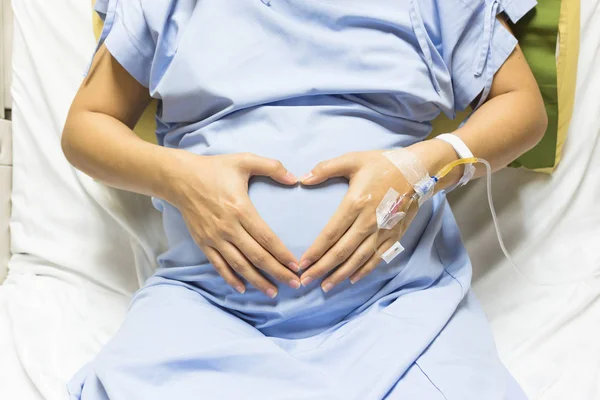 アジアの妊娠中の女性患者が病院 選択と集中で Vip ルームのベッドの上に食塩を受け取る心点滴を形の手 — ストック写真
