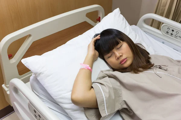 美丽的亚洲患者妇女头疼在病床在豪华房医院 — 图库照片