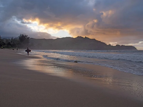 夏威夷考艾岛哈纳雷海滩 2018年11月 拿着车身的儿童冲浪者在日落时离开海洋 — 图库照片
