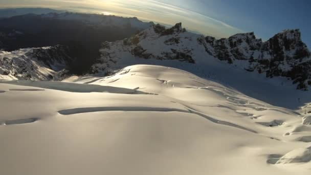 地面を明らかに雪崩キャニオン近く飛んで驚くほどの雪に覆われた山空中 — ストック動画