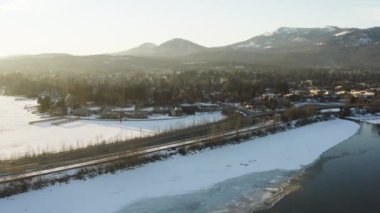 Sandpoint Idaho anteni şehir karlı kış günü günbatımı uzak uçan