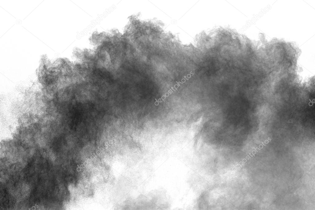 Black powder explosion on white background.Black dust particles splash.Painted Holi powder festival.