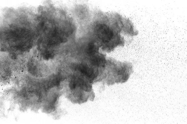 Black powder explosion on white background.Black dust particles splash.Painted Holi powder festival.