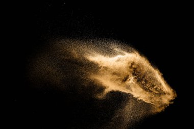 Altın kum patlaması siyah arka planda izole edildi. Soyut kum bulutu. Koyu arka planda altın renkli kum sıçraması. Sarı kum, havada uçan bir dalga..