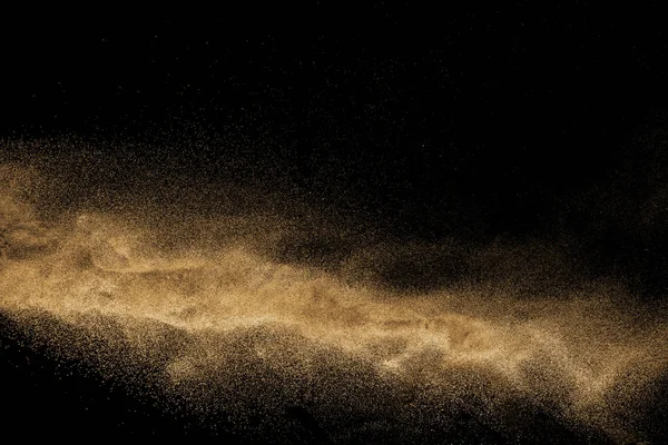 Kuru dere kum taş patlama ile. Sarı renkli kum sıçrama agianst koyu arka plan.