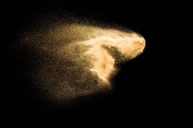 Kum patlaması siyah arka planda izole edildi. Kum tozunun hareketsiz hareketi sıçrıyor.