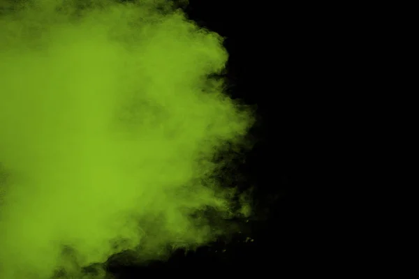 A splatter of green colored powder on black background.