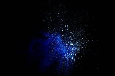 Mavi toz siyah arka plan üzerinde bulut patlayabilir. Başlatılan mavi toz parçacıkları arka planda sıçrama.