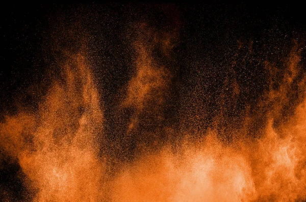 Pomarańczowy wybuch proszku na czarnym tle. Pomarańczowy kolor pyłu Splash. — Zdjęcie stockowe
