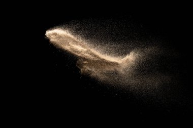 Kuru nehir kumu patlaması siyah arka planda izole edildi. Soyut kum bulutu. Kahverengi renkli kum koyu arkaplana sıçrar..