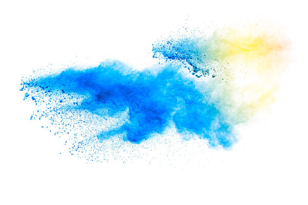 Abstract yellow blue dust explosion on white background. Freeze motion of yellow blue powder splash.