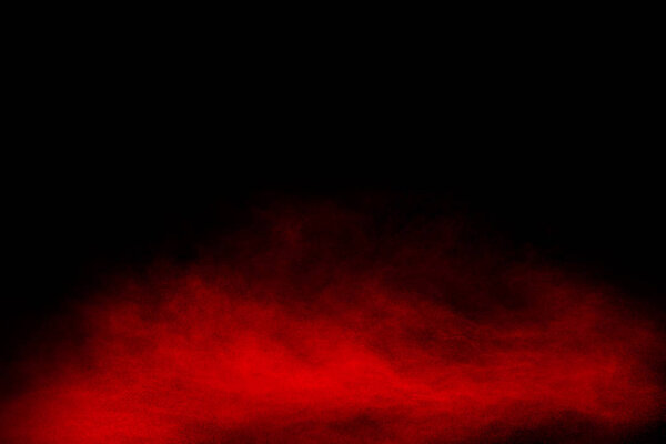 Red powder explosion cloud on black background.Freeze motion of Red dust particles splash.