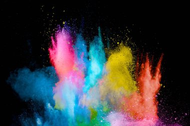 Explosion of colorful Holi powder on black background. Vibrant color dust particles textured background.
