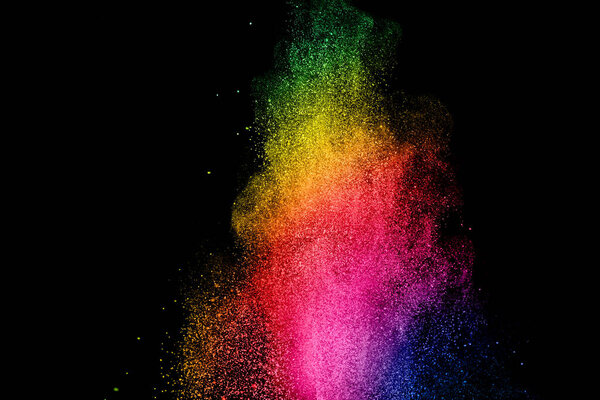 Launched multicolored powder on black background.Color powder explosion.Colorful dust splashing.