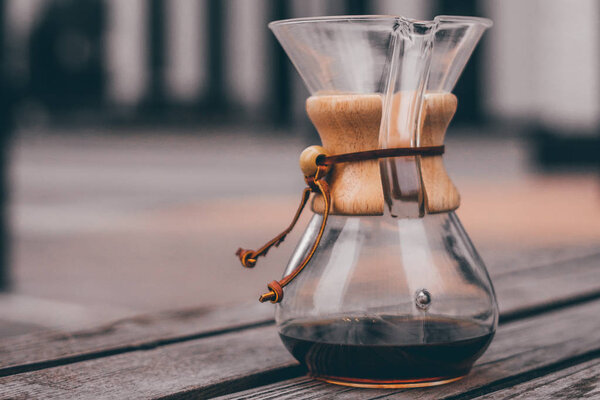 Closeup of coffee in glass flask on shabby wooden table