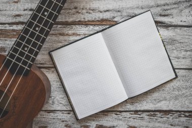 Ukulele gitar ve ahşap masa üzerinde dizüstü