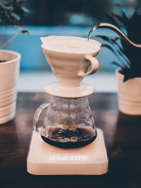 Pouring alternative brewing coffee on blue background