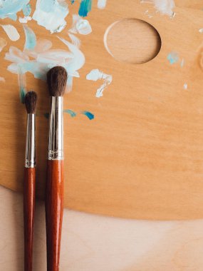 Petrol renk palet üzerinde ahşap masa portre üzerinde boya fırçaları