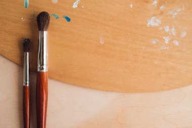 Petrol renk palet üzerinde ahşap masa portre üzerinde boya fırçaları