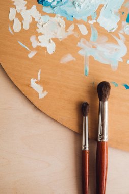 Petrol renk palet üzerinde ahşap masa portre üzerinde boya fırçaları
