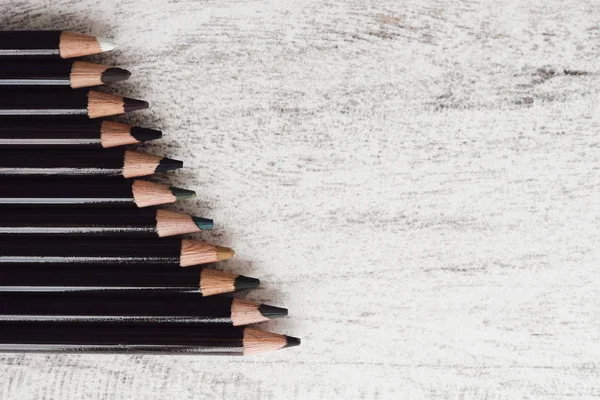 Ahşap arka plan üzerinde renkli kömür kalemler grubu