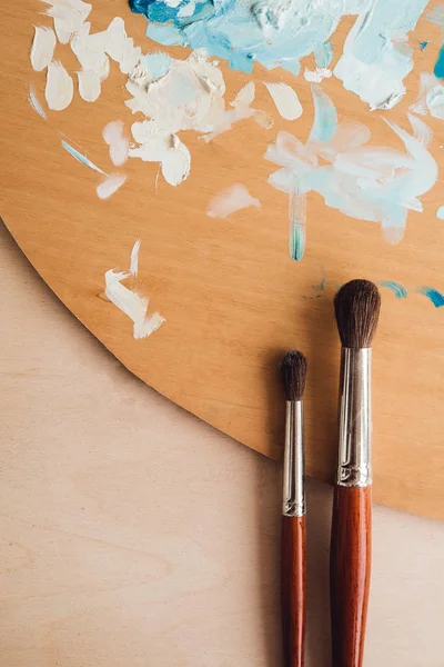 Petrol renk palet üzerinde ahşap masa portre üzerinde boya fırçaları