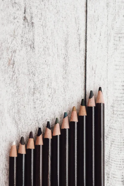 Group of color coal pencils on wooden background
