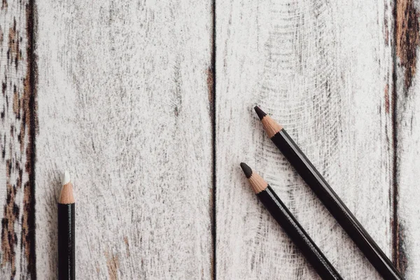 Ahşap arka plan üzerinde renkli kömür kalemler grubu