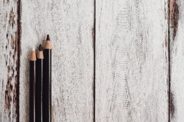 Ahşap arka plan üzerinde renkli kömür kalemler grubu