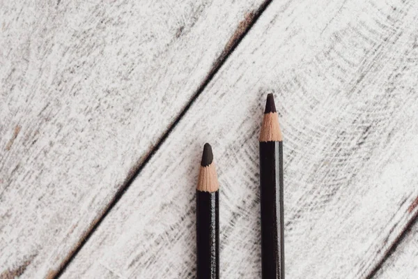 Ahşap arka plan üzerinde renkli kömür kalemler grubu