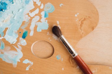 Petrol renk palet üzerinde ahşap masa portre üzerinde boya fırçaları