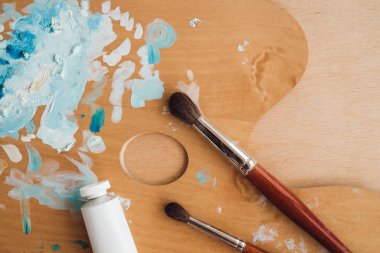 Petrol renk palet üzerinde ahşap masa portre üzerinde boya fırçaları