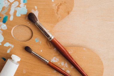 Petrol renk palet üzerinde ahşap masa portre üzerinde boya fırçaları