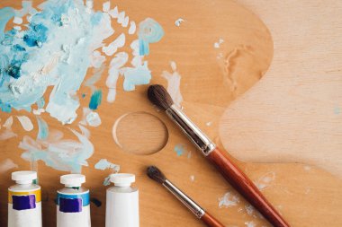 Petrol renk palet üzerinde ahşap masa portre üzerinde boya fırçaları