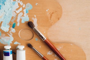 Petrol renk palet üzerinde ahşap masa portre üzerinde boya fırçaları