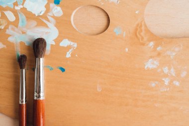 Petrol renk palet üzerinde ahşap masa portre üzerinde boya fırçaları