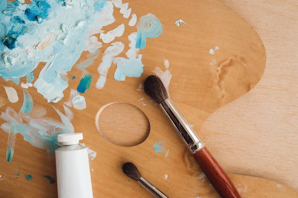 Petrol renk palet üzerinde ahşap masa portre üzerinde boya fırçaları